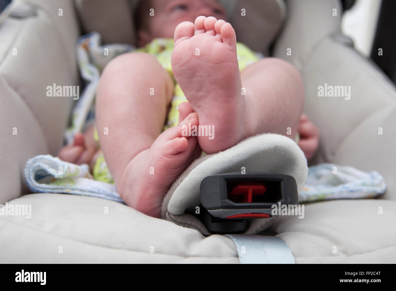 Chubby pieds d'un bébé nouveau-né garçon dans la poussette pendant que sur une promenade à l'extérieur dans la rue Banque D'Images