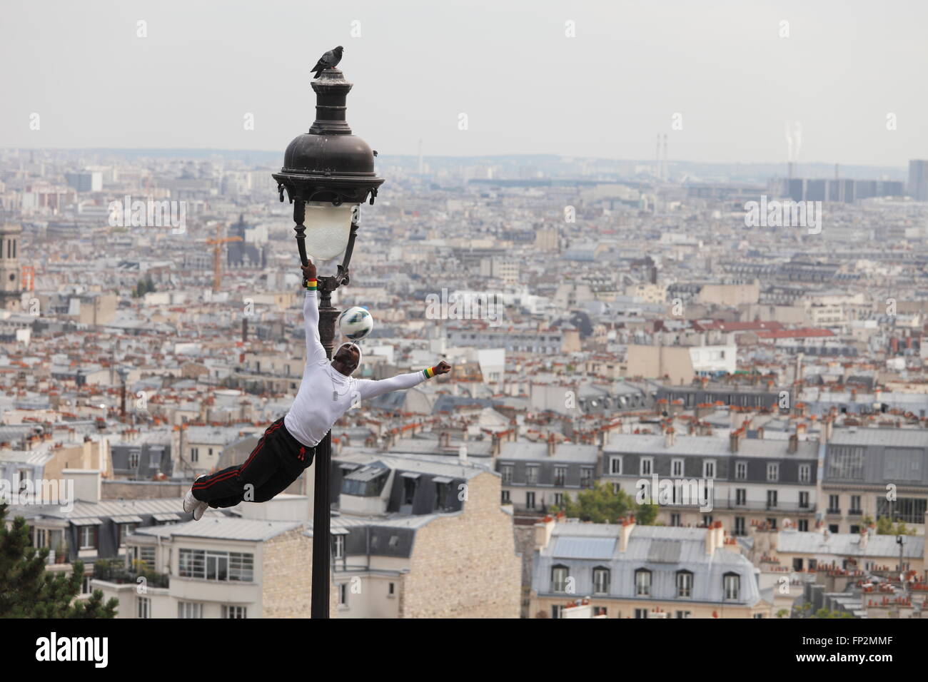 Artiste de performance acrobatique sur une vieille lampe à gaz sur la colline du Sacré Coeur de Montmartre - Paris, France Banque D'Images