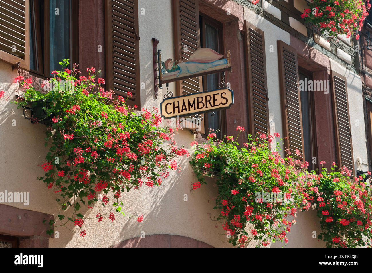 Français B + B Gite 'chambres' signe avec charmante charmante rustique fleurs colorées pélargoniums fleuris et volets de fenêtre France Banque D'Images