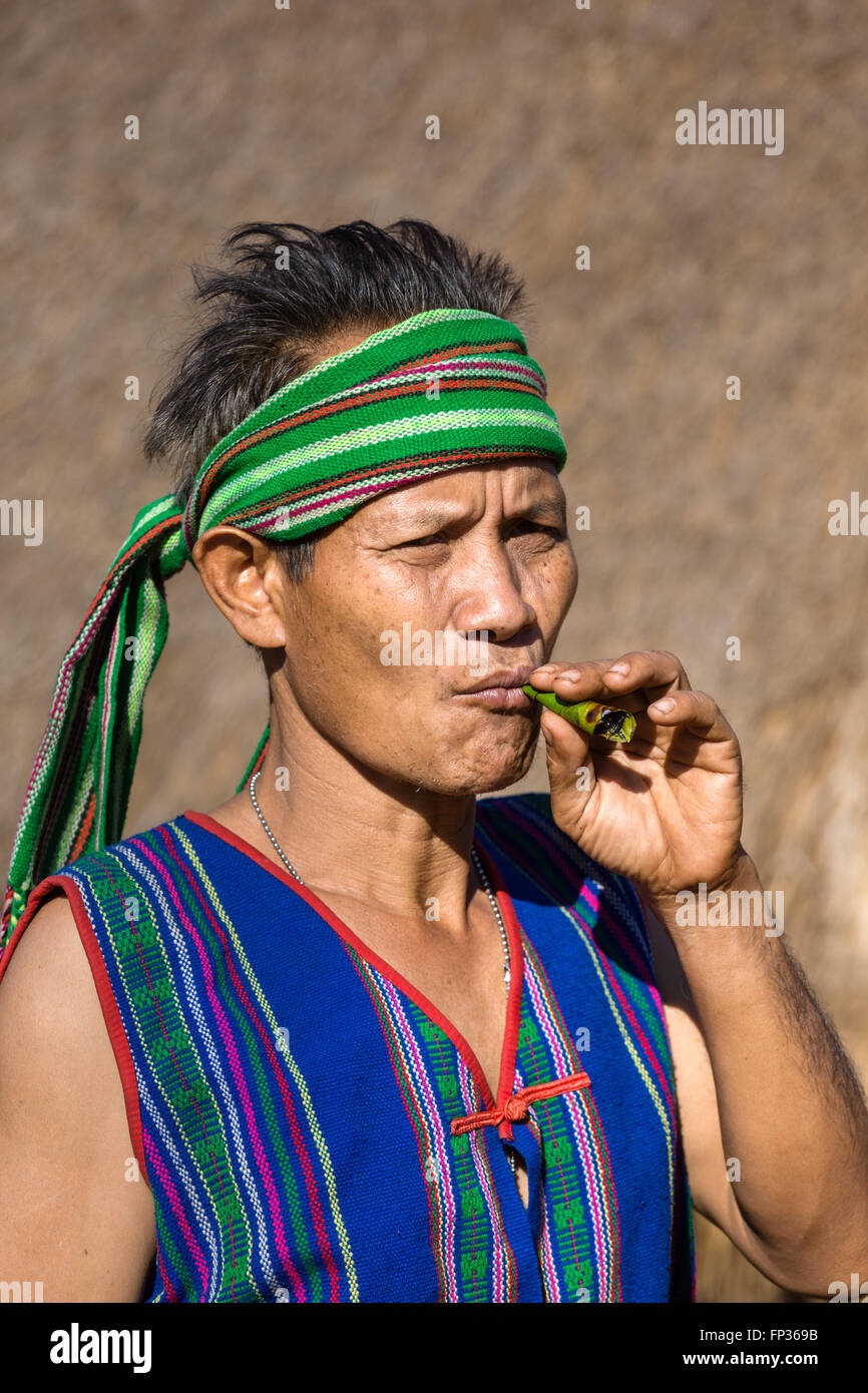 L'homme en costume traditionnel fumeurs de cigare, tribu Phnong, minorité ethnique, Pnong, Bunongs, Senmonorom, Sen Monorom Banque D'Images