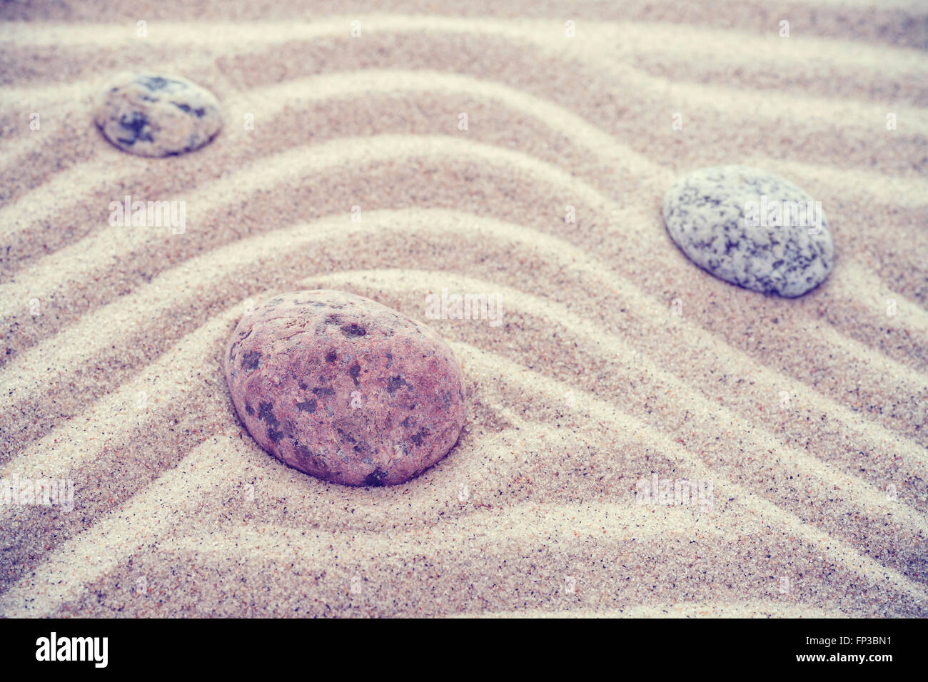 Des pierres aux tons Vintage sur les vagues de sable, la nature et l'harmonie concept. Banque D'Images