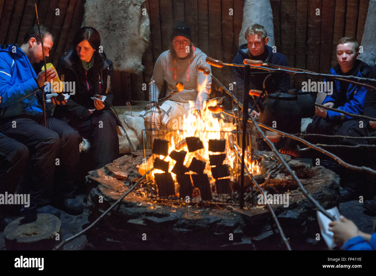 Salla, Laponie, Finlande. Les gens de rennes rencontrez des hamburgers à l'intérieur de la cuisine dans une des huttes. Huttes de gazon et de base Banque D'Images Salla, Laponie, Finlande. Les gens de rennes rencontrez des hamburgers à l'intérieur de la cuisine dans une des huttes. Huttes de gazon et de base Banque D'Images