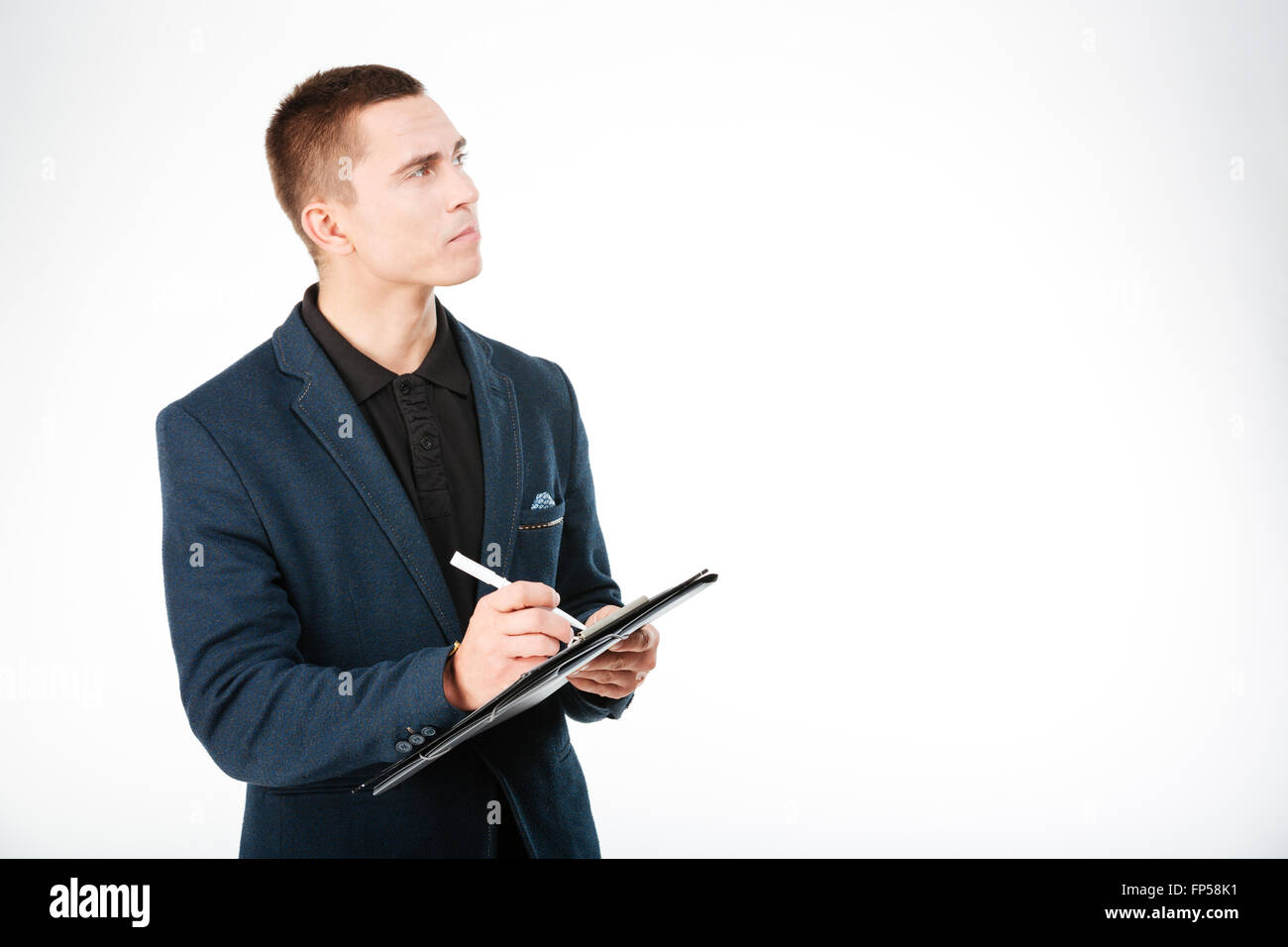 Pensive businessman holding clipboard and looking up isolé sur fond blanc Banque D'Images