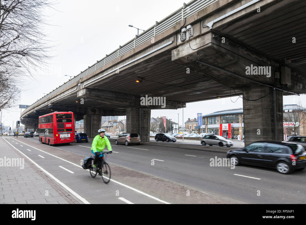 Le trafic sur l'A4 et d'un cycliste sur une voie cyclable avec une section de l'autoroute M4 en frais généraux, Brentford, London, England, UK Banque D'Images