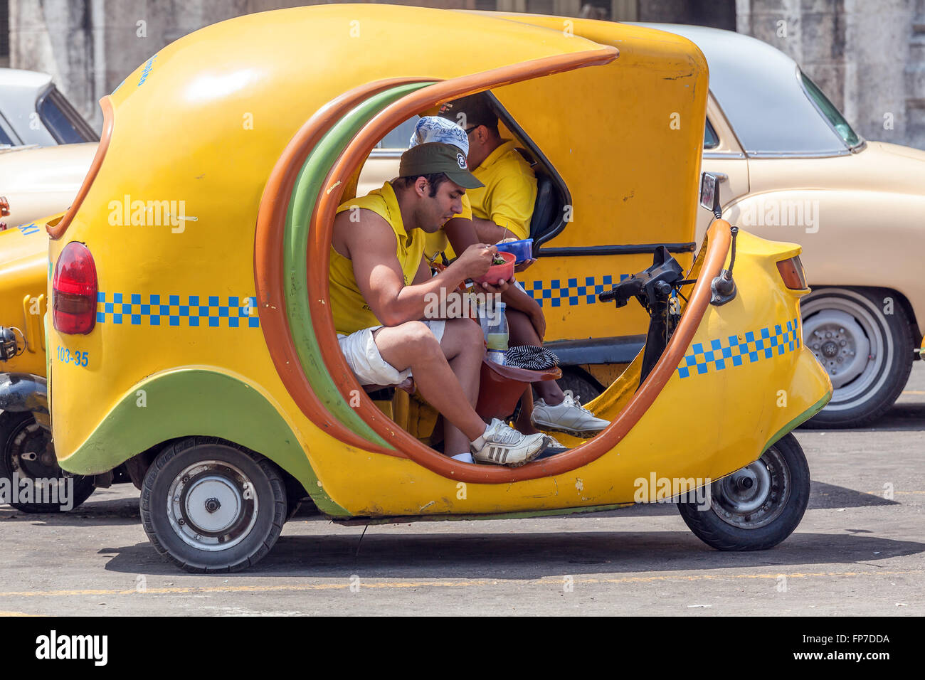 La HAVANE, CUBA - 1 avril 2012 : young man having lunch in yellow taxi moto Banque D'Images