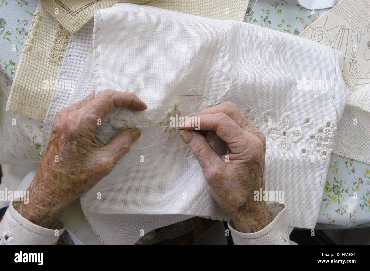 Libre d'une vieille femme de mains alors qu'elle travaille sur un tablier de dentelle hardanger. Banque D'Images