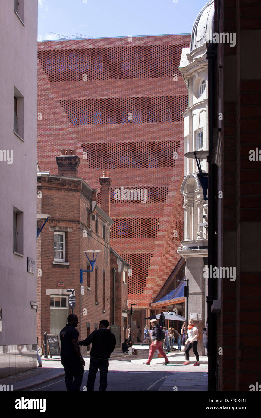 L'angle de mur en brique et en verre forte entrée de la LSE Student Center conçu par O'Donnell & Tuomey Architects, vu au fond d'une ruelle qui a personnes milling à ce sujet. Banque D'Images