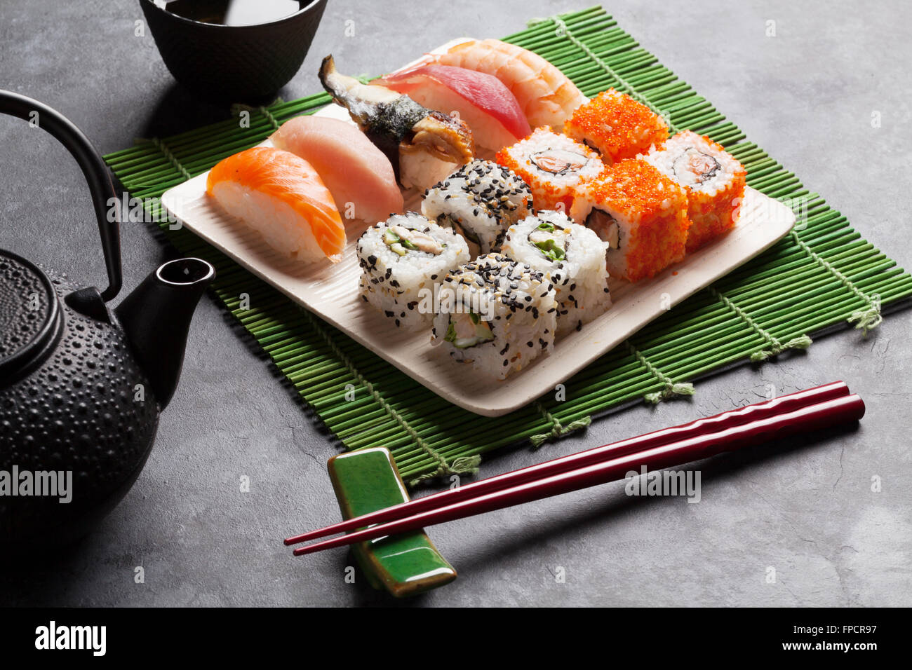 Ensemble de sushi, maki et thé vert sur table en pierre Banque D'Images