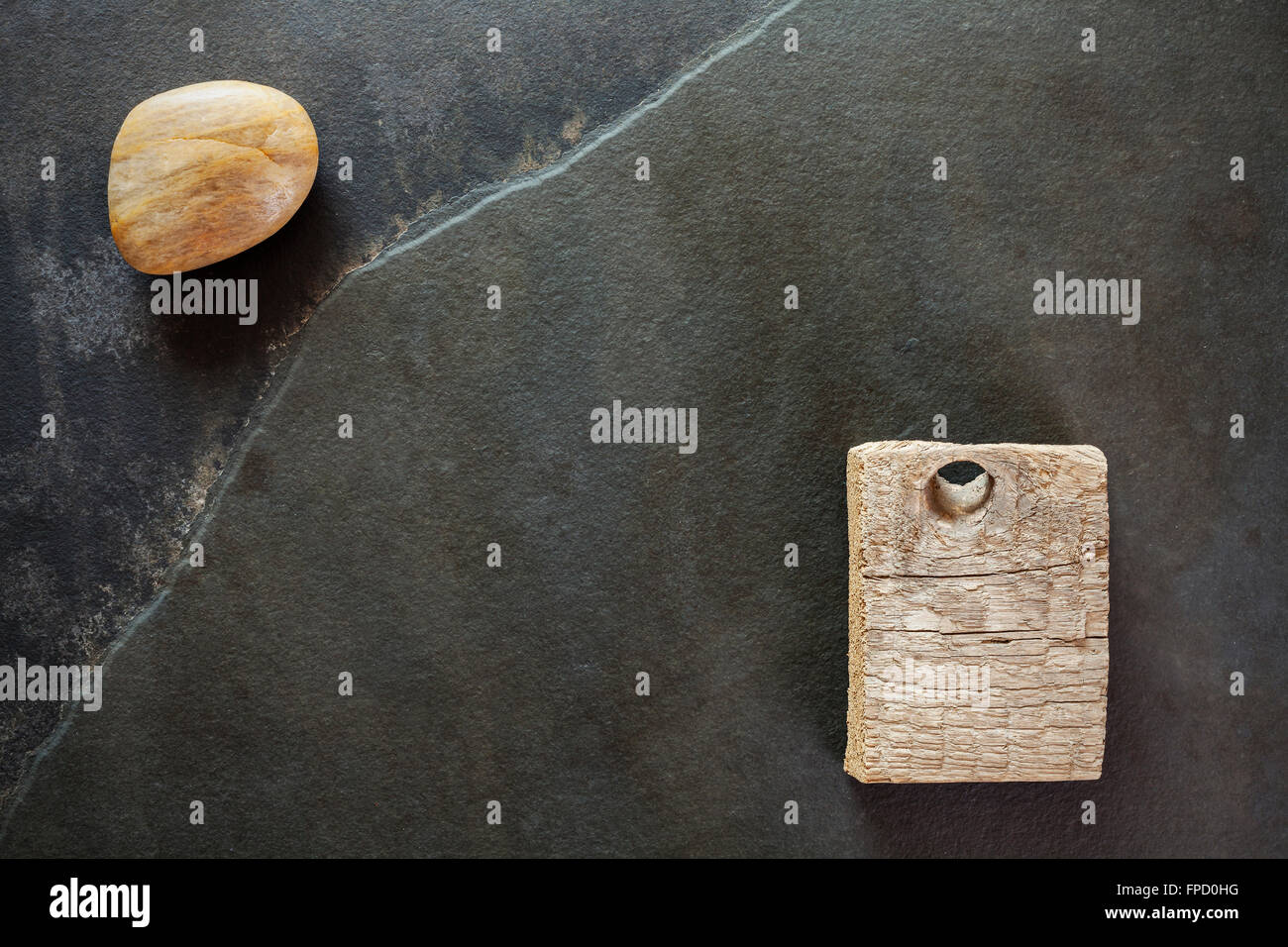 La pierre et le morceau de bois sur l'ardoise, abstract background. Banque D'Images