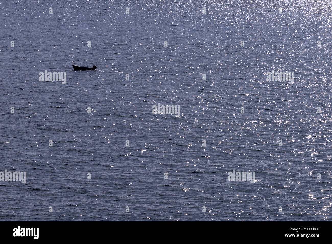 Un seul pêcheur sur une mer scintillante Mer Adriatique, près de Dubrovnik, Croatie. Banque D'Images
