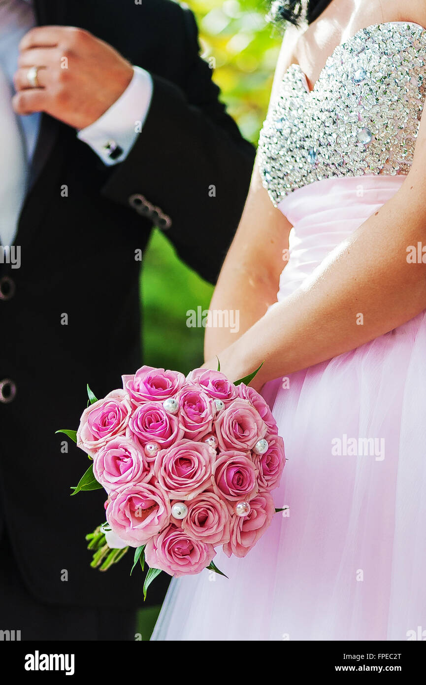 Mariage bouquet de roses roses dans les mains de la mariée Banque D'Images