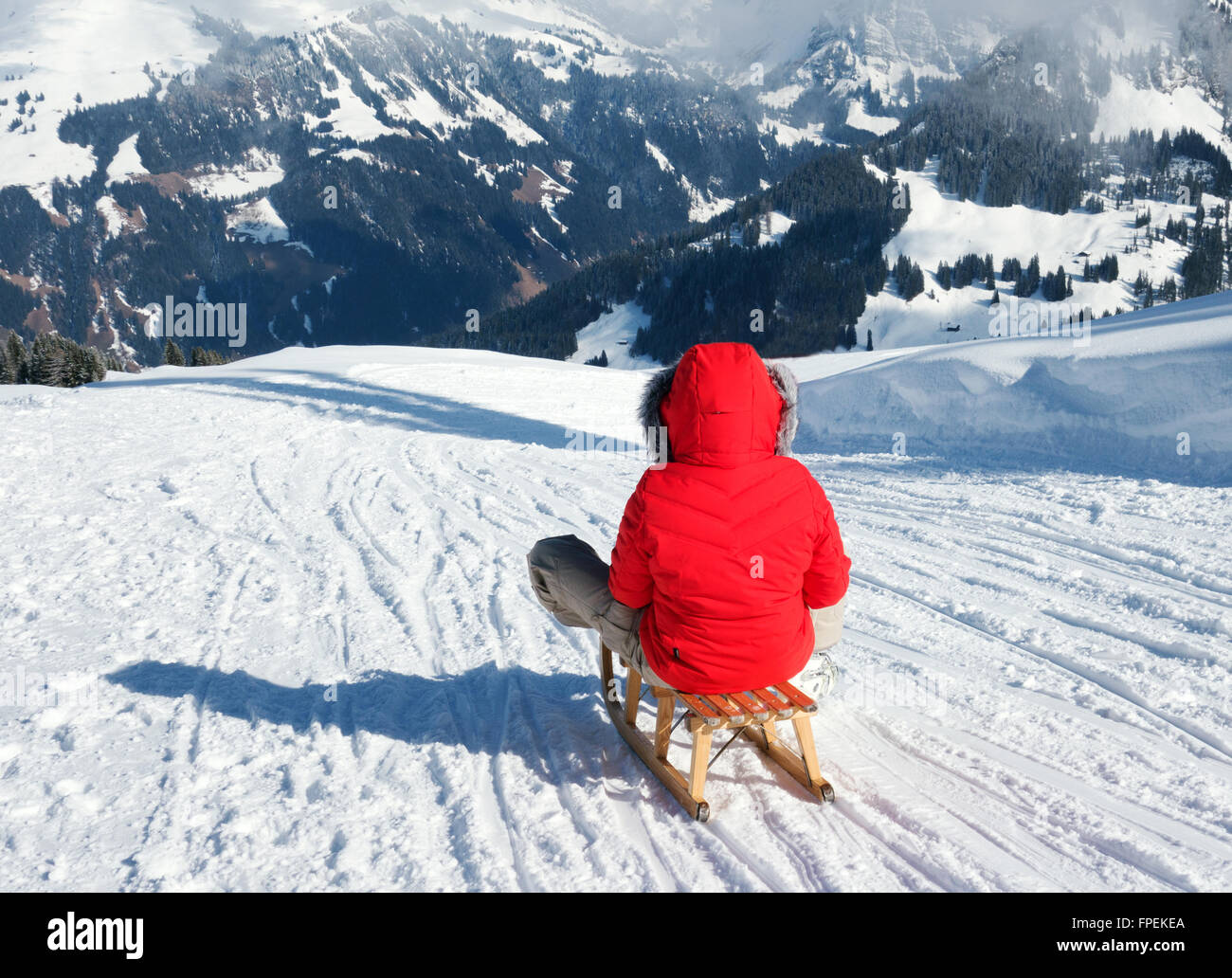 Une jeune femme de la luge dans les Alpes Suisses en vacances, à Lenk, Canton de Berne, Suisse Europe Banque D'Images