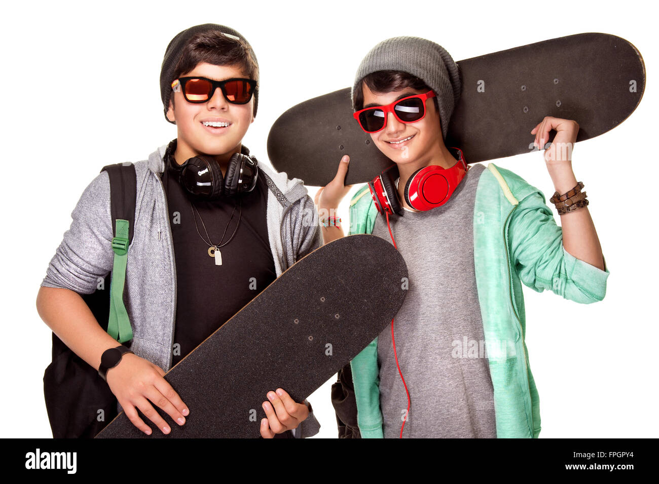 Portrait de deux happy teen boys avec skateboards isolé sur fond blanc, cool look tendance, de vie des jeunes urbains actifs Banque D'Images