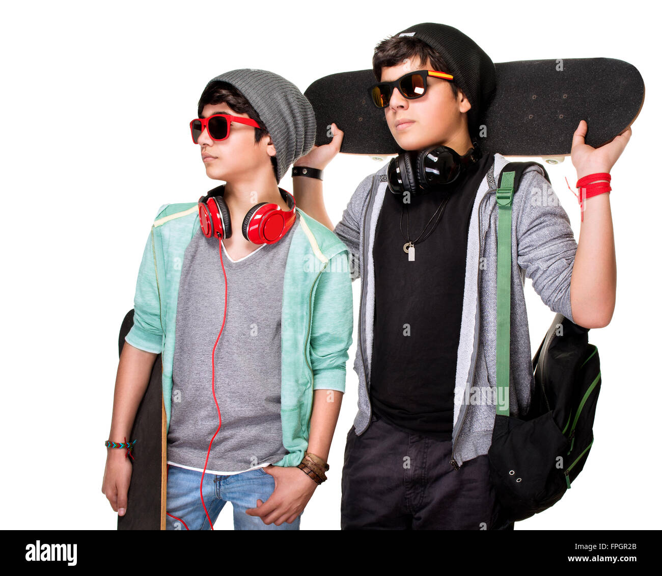 Portrait de deux garçons sérieux avec skateboards posant dans le studio, les adolescents élégante isolé sur fond blanc, la vie de la jeunesse Banque D'Images