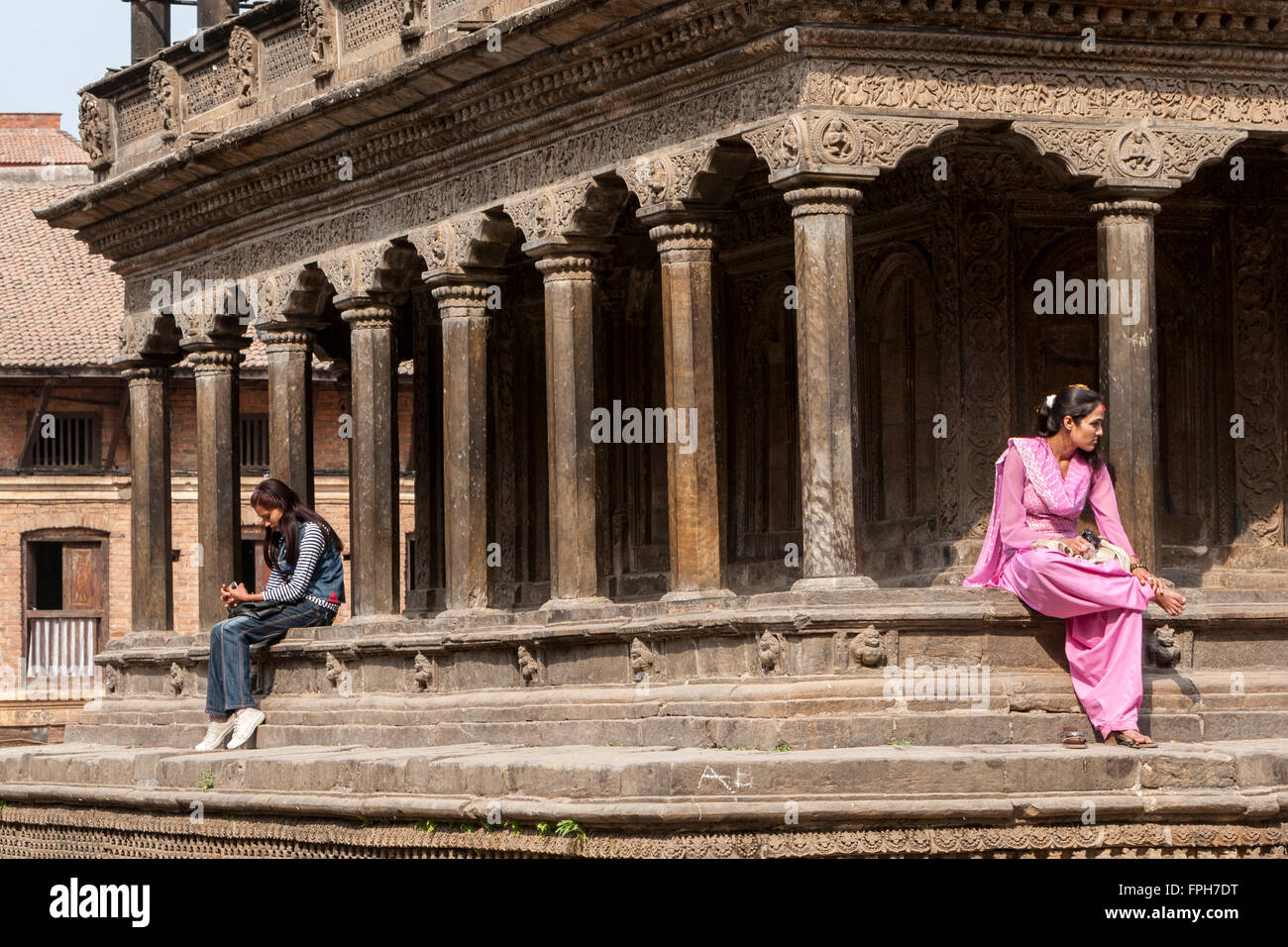 Le Népal, Patan. Deux jeunes femmes népalaises, l'un dans l'ouest de l'habillement, l'un de style traditionnel. Banque D'Images