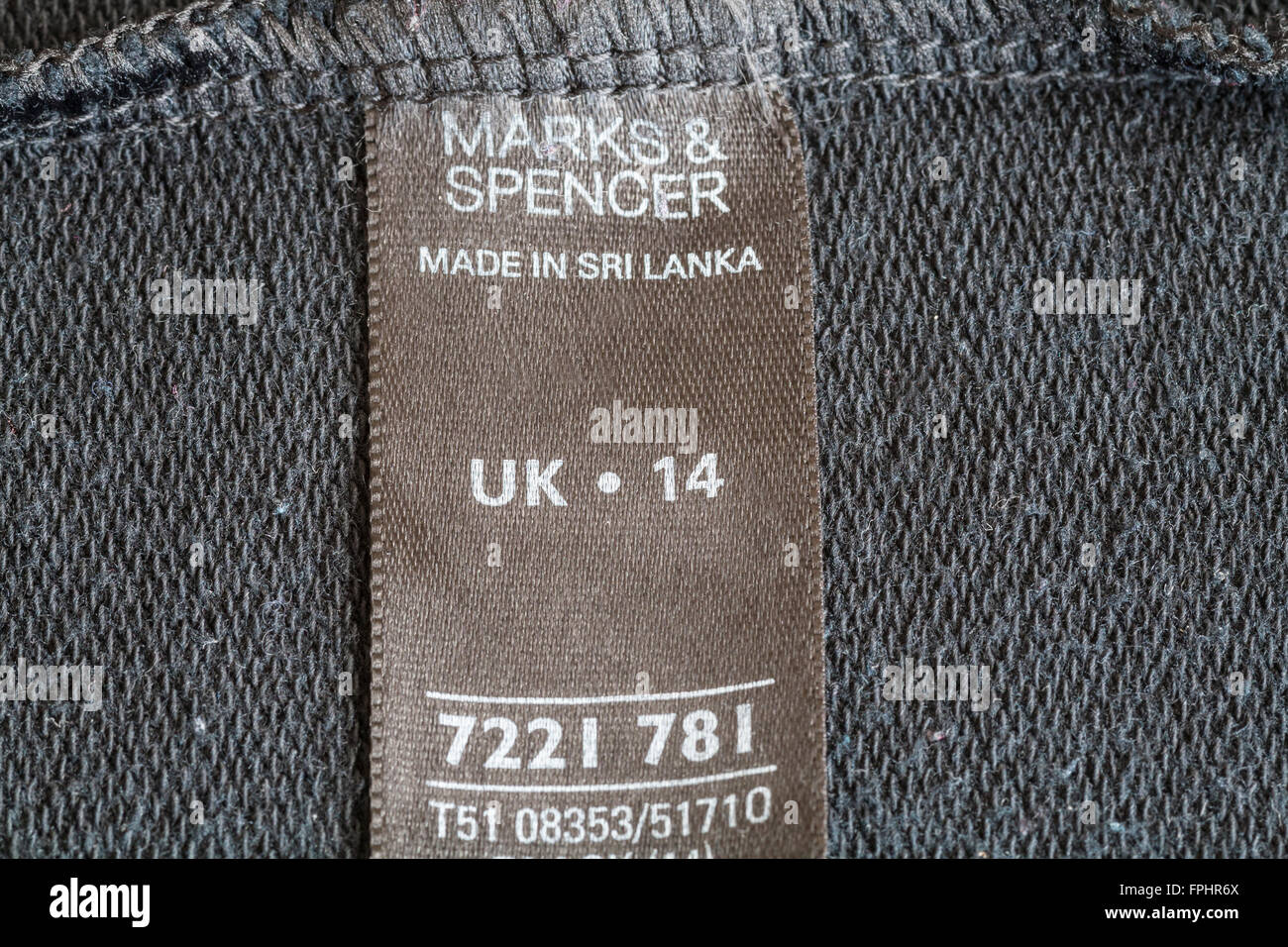 Étiquette à l'intérieur du vêtement femme taille 14 vendu par Marks et Spencer faite au Sri Lanka produit fabriqué à faible coût d'importation bon marché Banque D'Images