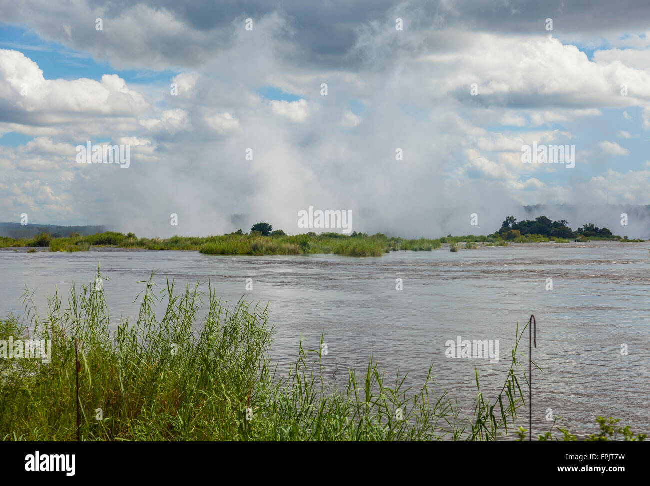 Vue sur le fleuve Zambèze vers oa Tunya Mosi, la fumée qui tonne", le spray surgissant des Chutes Victoria, la Zambie. Banque D'Images