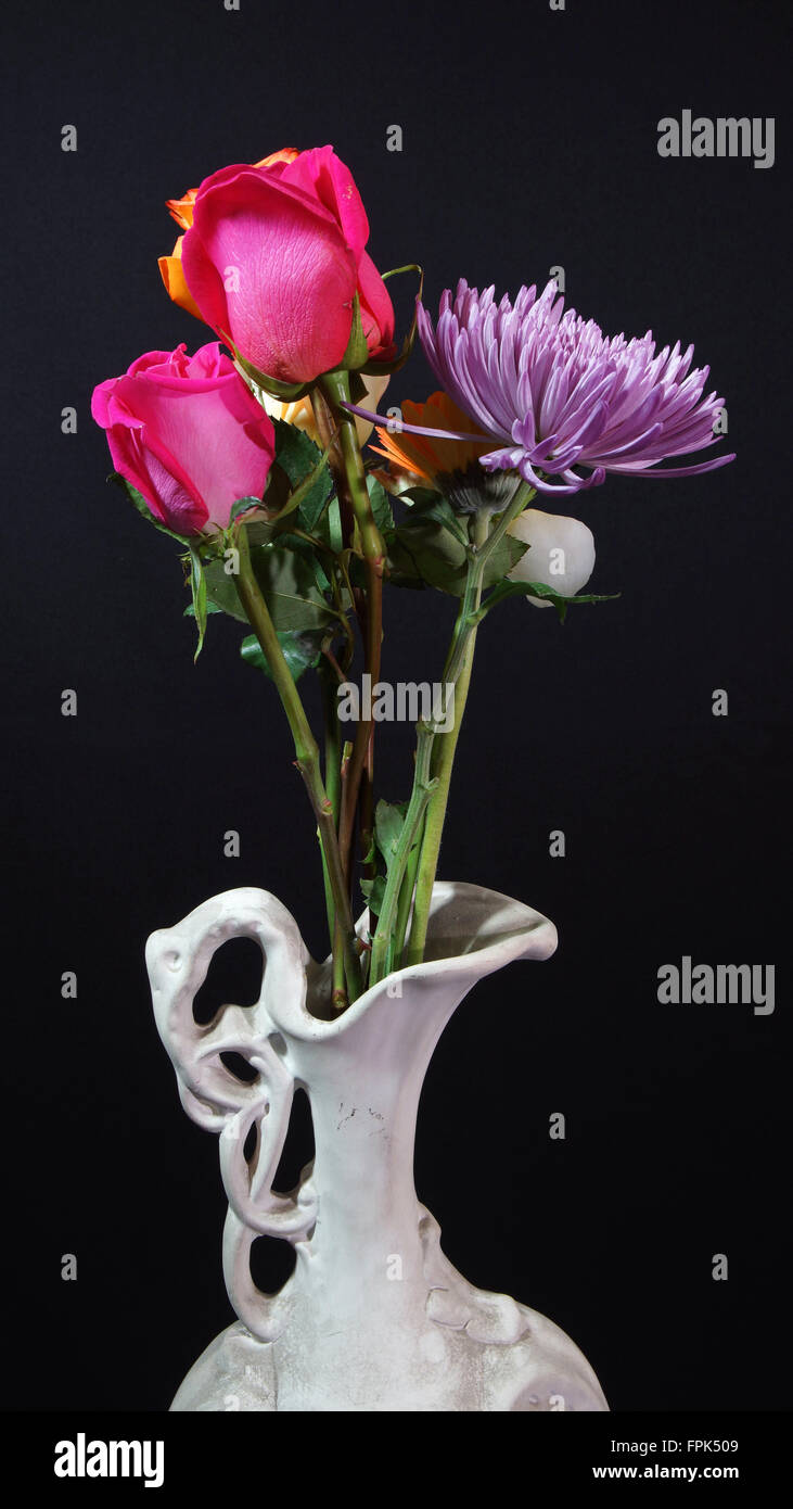 Fleurs dans vase en céramique blanc sur fond sombre Banque D'Images
