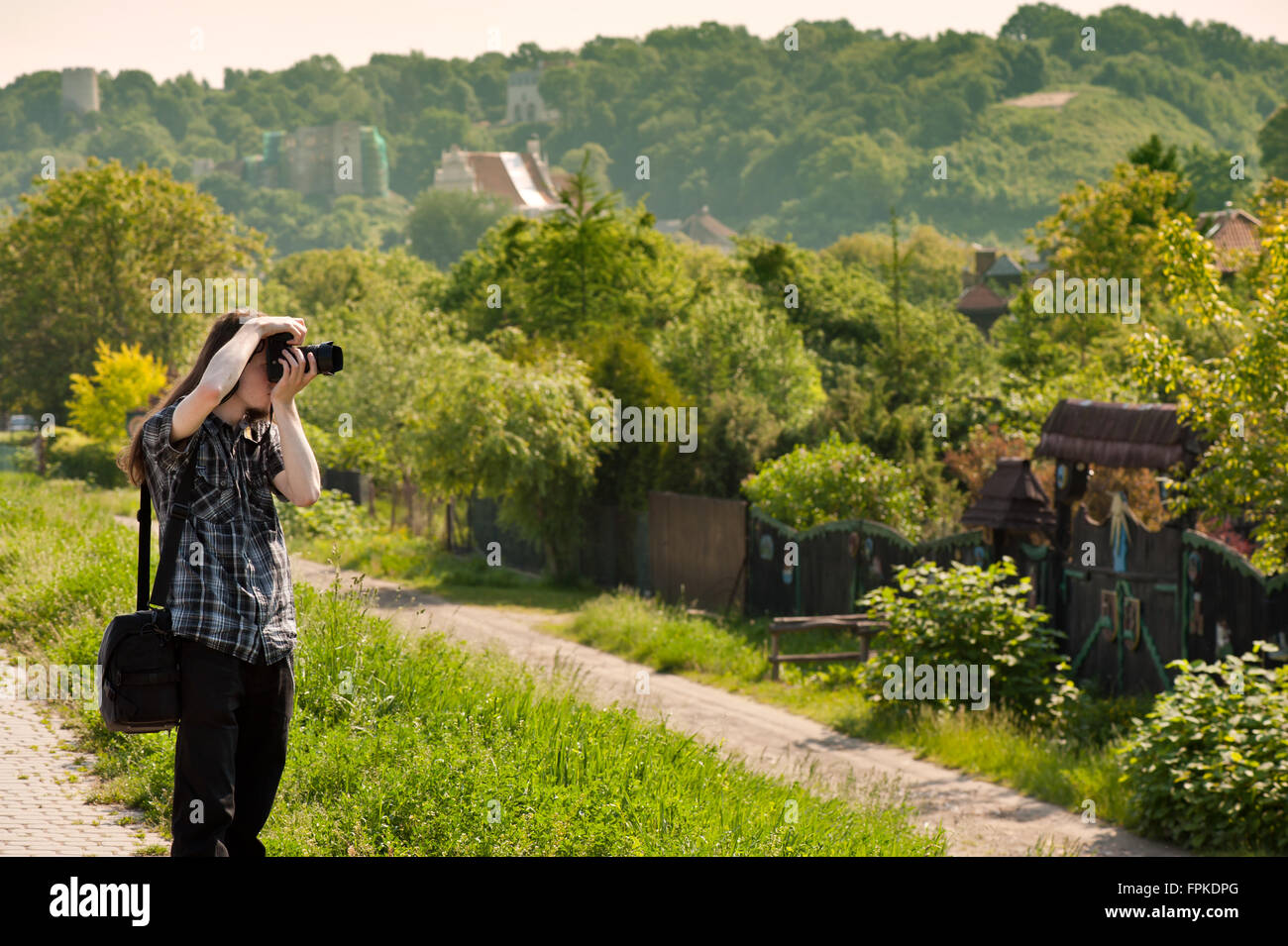 Man taking photo de la ville paysage au cours de visites, de longs cheveux noirs habillé jeune prise en main de l'appareil près de l'œil Banque D'Images