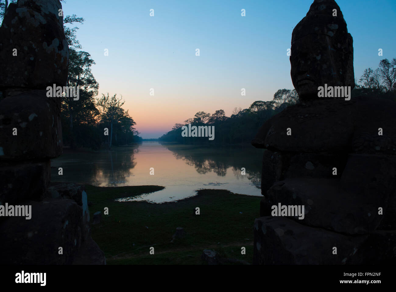 Coucher du soleil sur le pont-jetée à la Porte Sud d'Angkor Thom avec les dieux et les démons tirant sur un serpent géant menant à la ville Banque D'Images