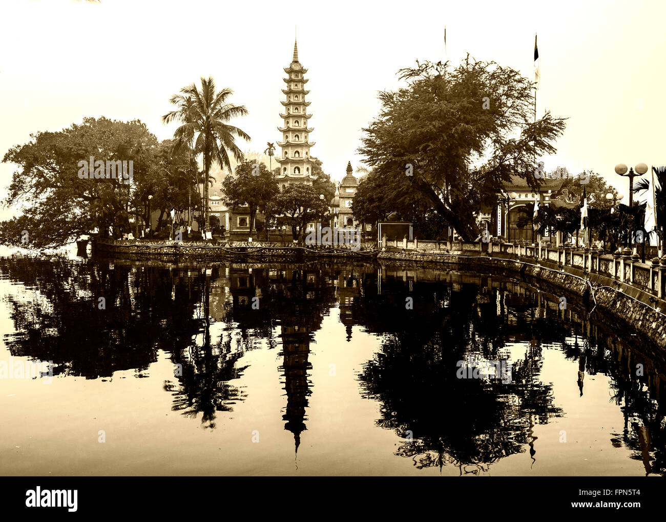 Personnes âgées et les Buddist viewof teinté la Pagode Tran Quoc et du temple sur le Lac Ho Tay sur une journée Janvier brumeux, Hanoi, Vietnam. Banque D'Images