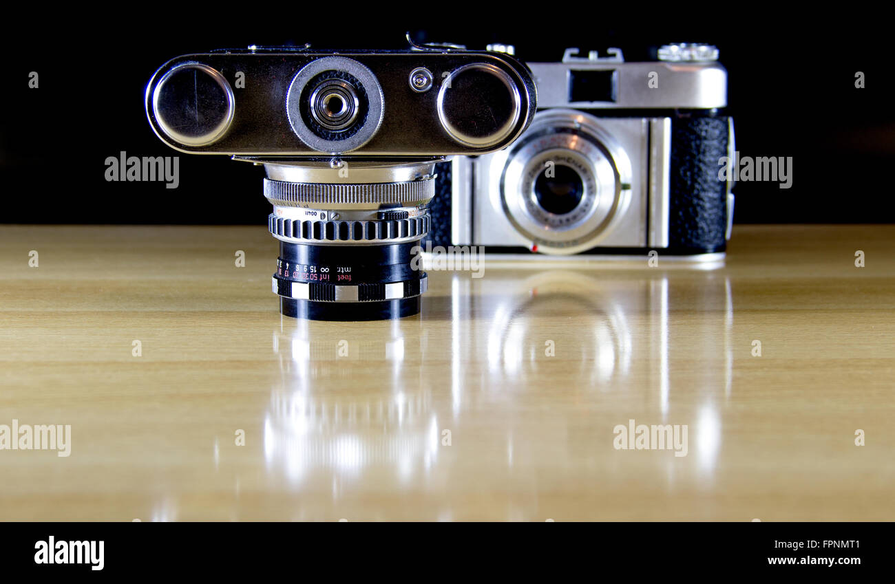 Deux anciennes caméras 35mm analogique présentée sur une table en bois Banque D'Images