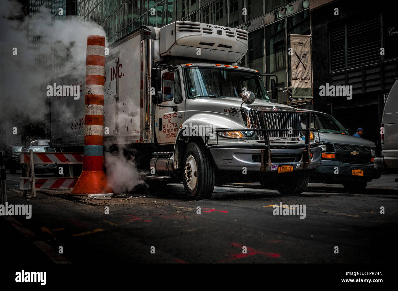 Chariot à vapeur et d'être évacué à travers une vapeur Con Edison typique pile orange et blanc, New York City, USA. Banque D'Images