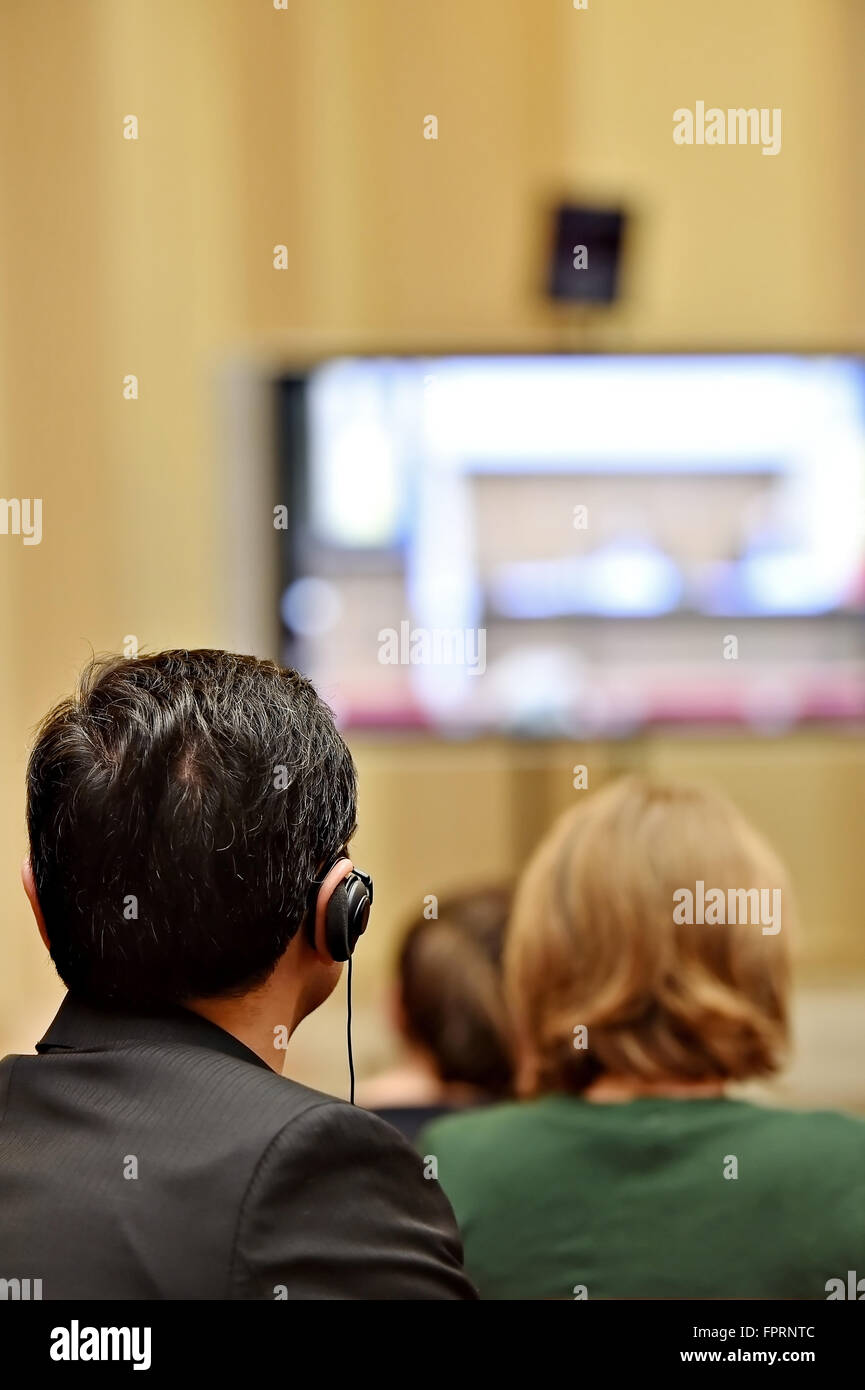 À l'aide de personnes méconnaissables dans l'oreille d'écouteurs pour la traduction pendant l'événement Banque D'Images