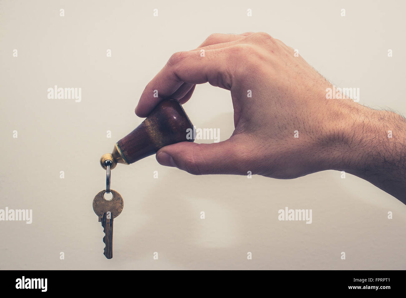 Hand holding hôtel key sur fond blanc , effet filtre vintage Banque D'Images