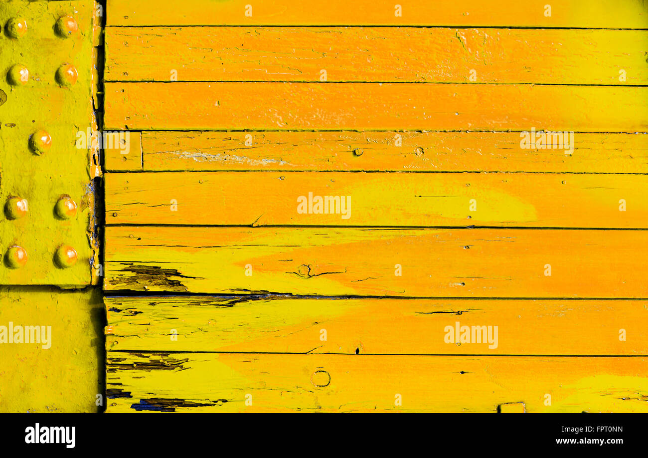 Bois de couleur vive orange jaune avec fond grunge 12.2005 conseils et une plaque de métal avec des rivets dans une texture full frame Banque D'Images