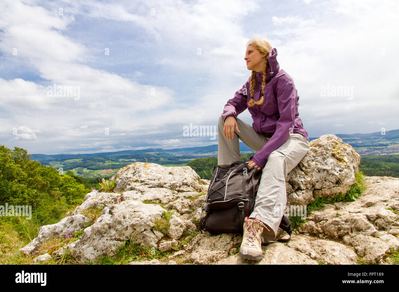 Jeune femme assise sur un pic de montagne Banque D'Images