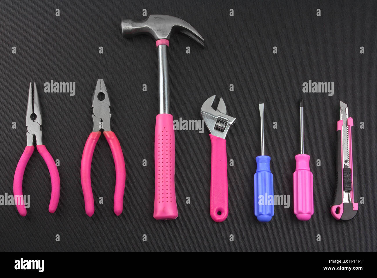 Un étrange outil de couleur entre les outils avec toutes les poignées rose Banque D'Images
