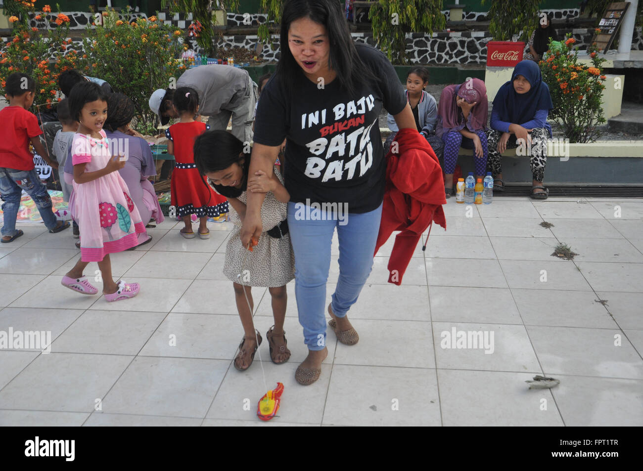 Makassar, Indonesa. Mère et fils jouer à un espace public. Banque D'Images