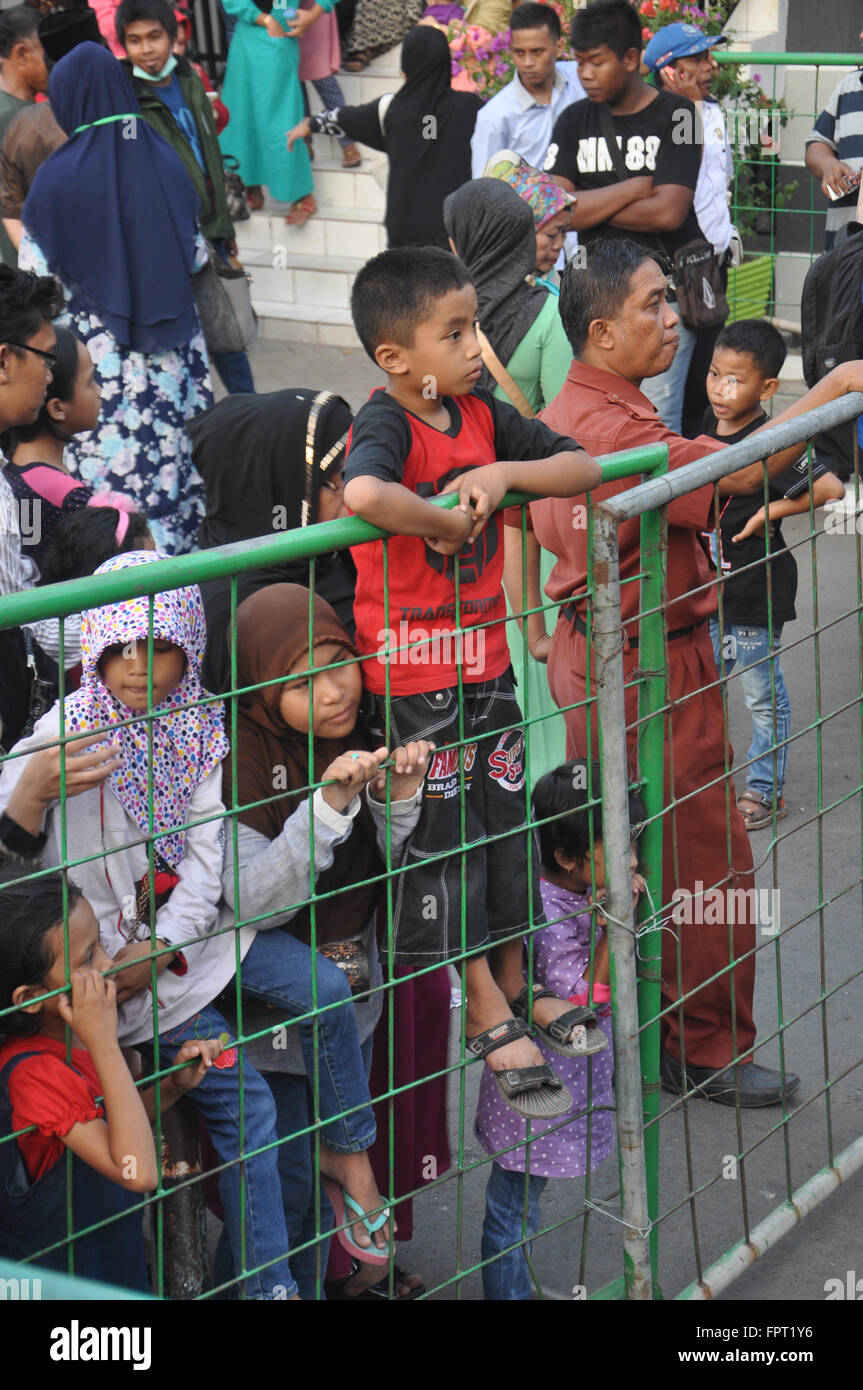 Makassar, Indonesa. Les enfants attendre la famille qui vient d'arriver à partir de la Mecque. Banque D'Images