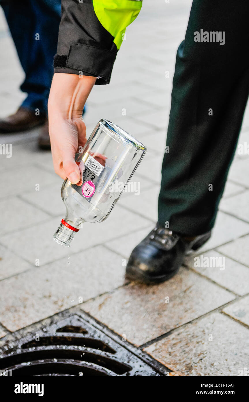 Belfast, Irlande du Nord. 17 Mar 2016 - agents de police PSNI disposer d'alcool confisquées à des jeunes. Banque D'Images