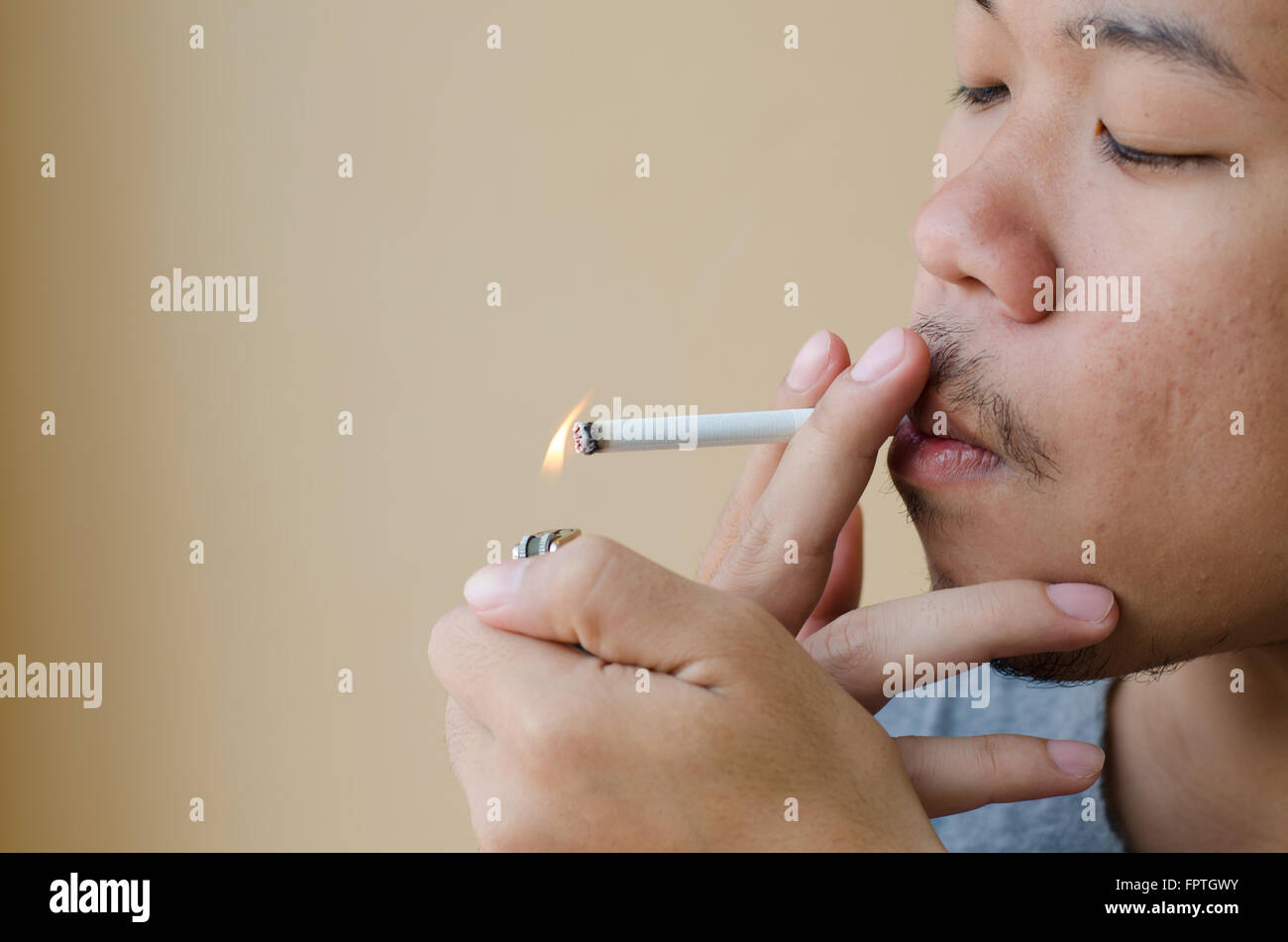 Asian young man smoking cigarette Banque D'Images