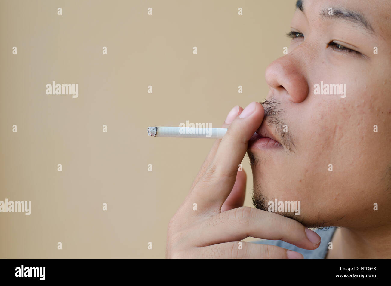 Asian young man smoking cigarette Banque D'Images