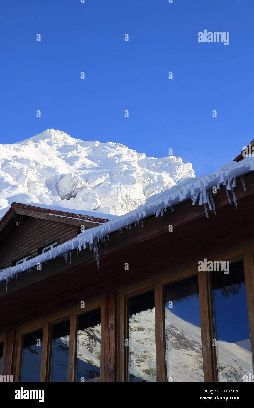 Glaçons pendant l'extérieur du bord de la toiture d'un chalet à Balea Lac, en hiver, dans les montagnes de Transylvanie, Faragas Banque D'Images