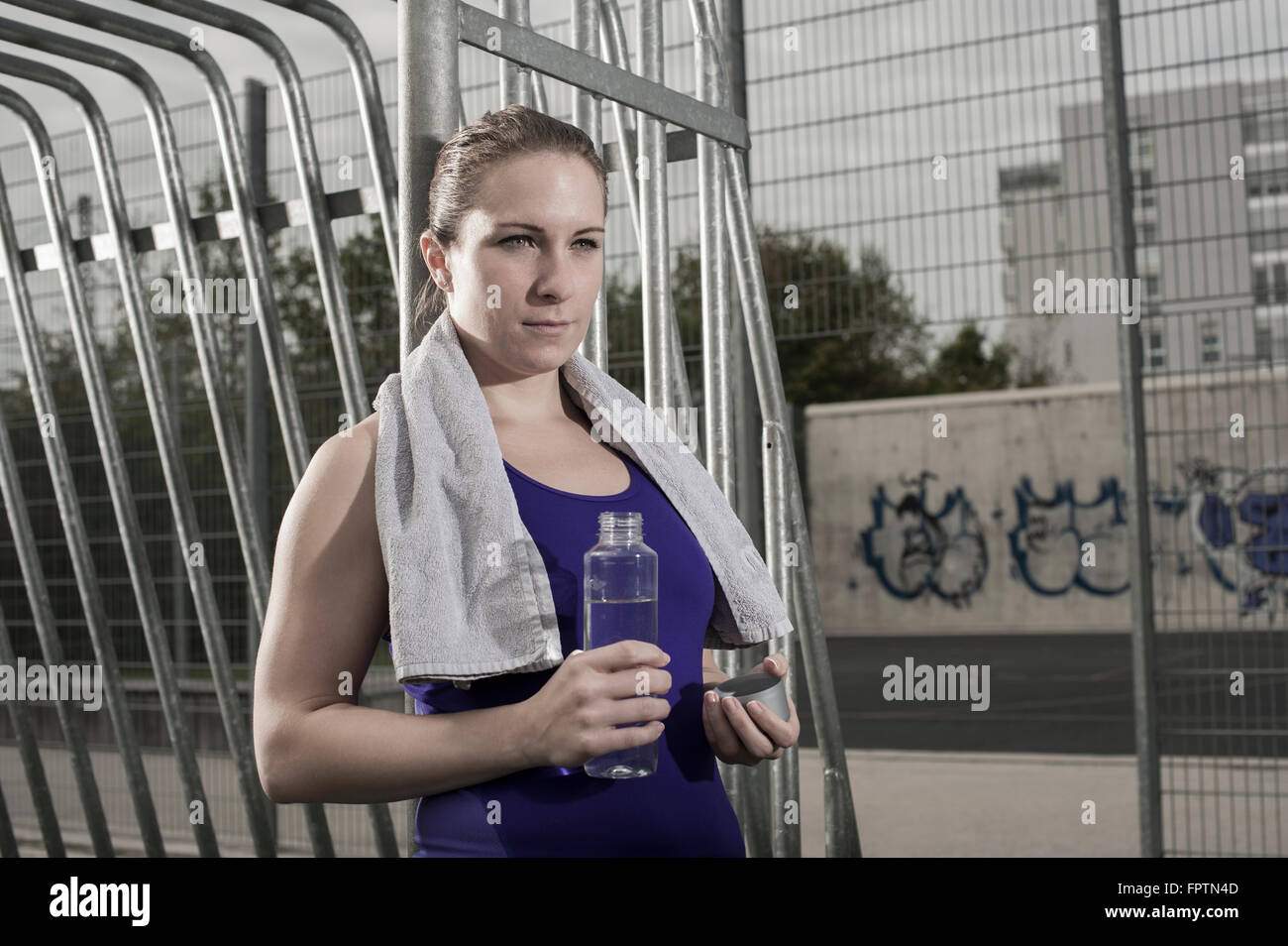 Jeune femme à boire de l'eau sur terrain de football, Bavière, Allemagne Banque D'Images