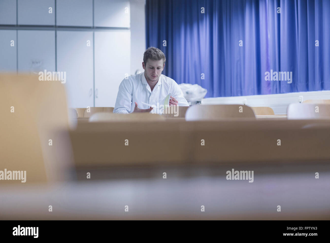 Jeune homme livre lecture scientifique dans la salle de cours, Freiburg im Breisgau, Bade-Wurtemberg, Allemagne Banque D'Images
