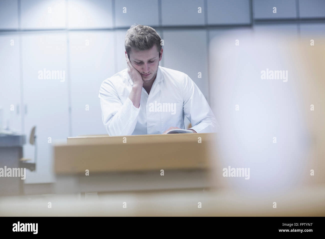 Jeune homme livre lecture scientifique dans la salle de cours, Freiburg im Breisgau, Bade-Wurtemberg, Allemagne Banque D'Images