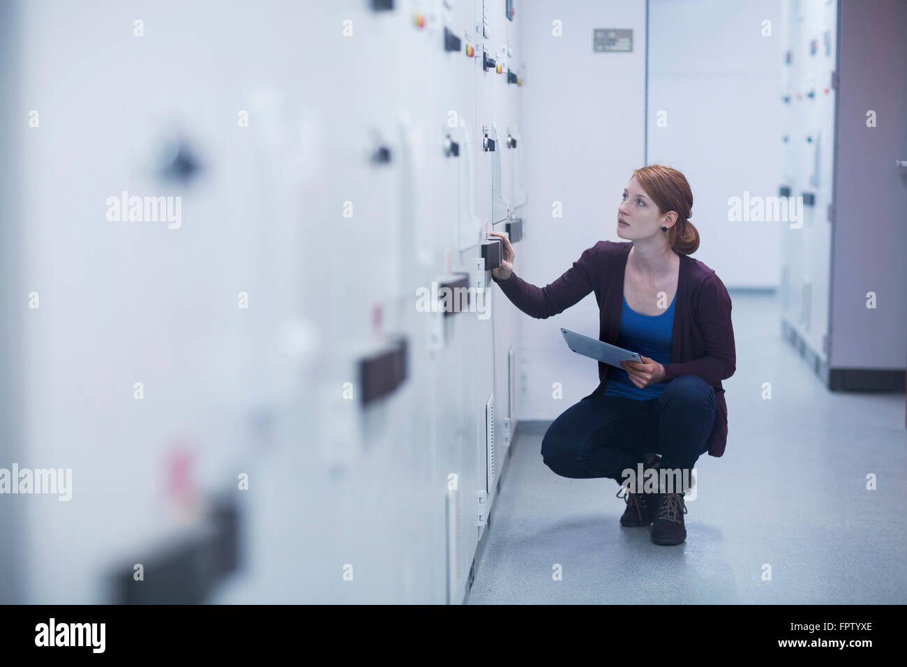 Jeune ingénieur femelle panneau de mise à jour par tablette numérique dans une industrie, Freiburg im Breisgau, Bade-Wurtemberg, Allemagne Banque D'Images