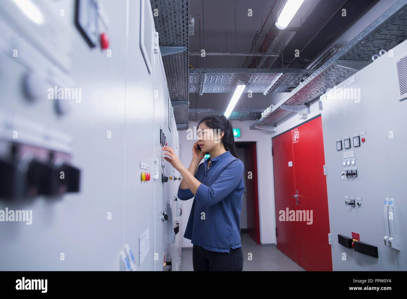 Jeune ingénieur en utilisant le panneau de mise à jour téléphone mobile dans une industrie, Freiburg im Breisgau, Bade-Wurtemberg, Allemagne Banque D'Images