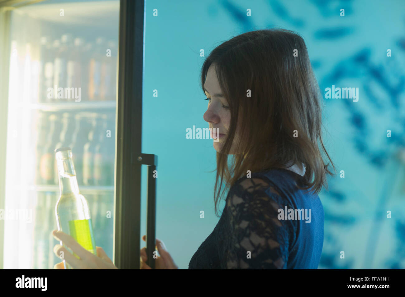 Jeune femme tenant une bouteille de soda de réfrigérateur, Freiburg im Breisgau, Bade-Wurtemberg, Allemagne Banque D'Images