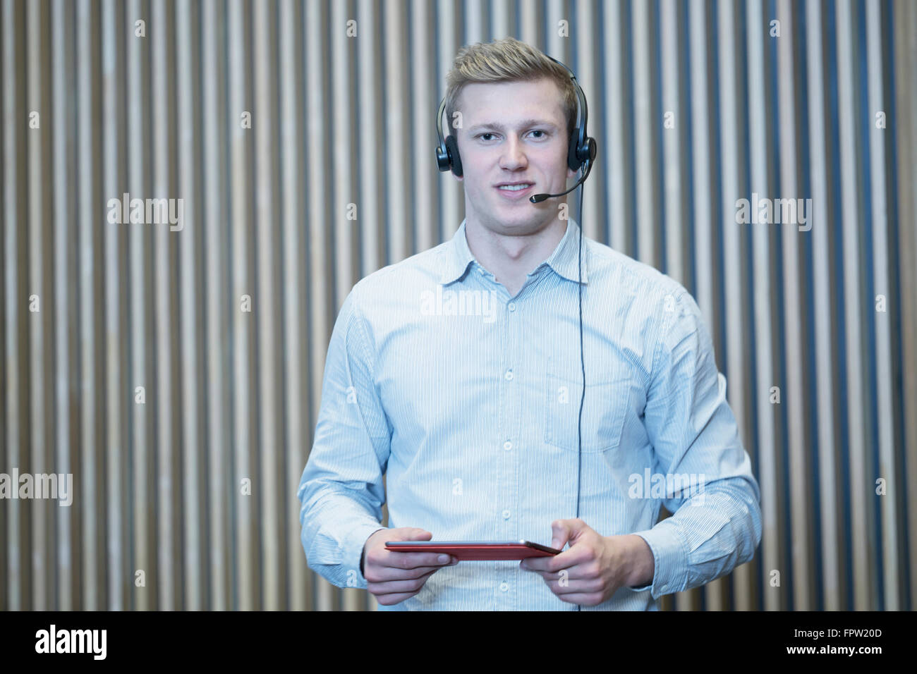 Jeune étudiant holding digital et de l'onglet lecture en salle de conférence, Freiburg im Breisgau, Bade-Wurtemberg, Allemagne Banque D'Images