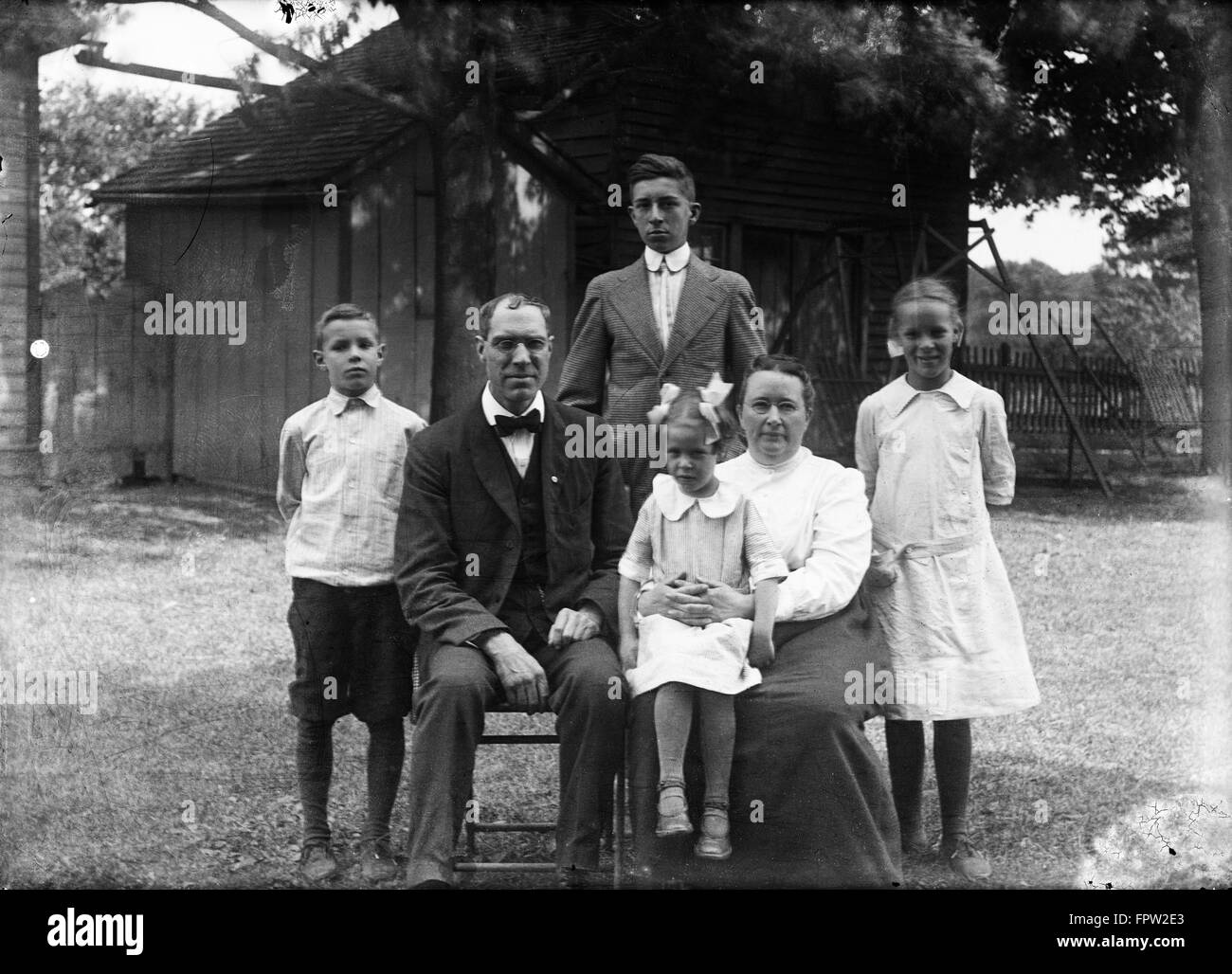 Années 1900 1918 Portrait de famille Père Mère ENFANTS DEUX FILS, DEUX FILLES POSANT DEHORS DANS LA COUR LOOKING AT CAMERA Banque D'Images