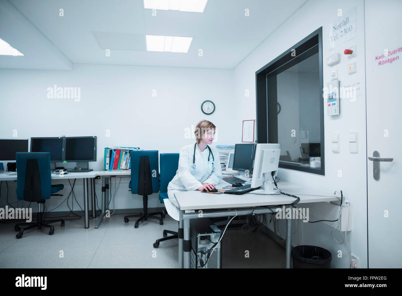 Jeune femme médecin travaillant sur ordinateur à l'hôpital, Freiburg im Breisgau, Bade-Wurtemberg, Allemagne Banque D'Images