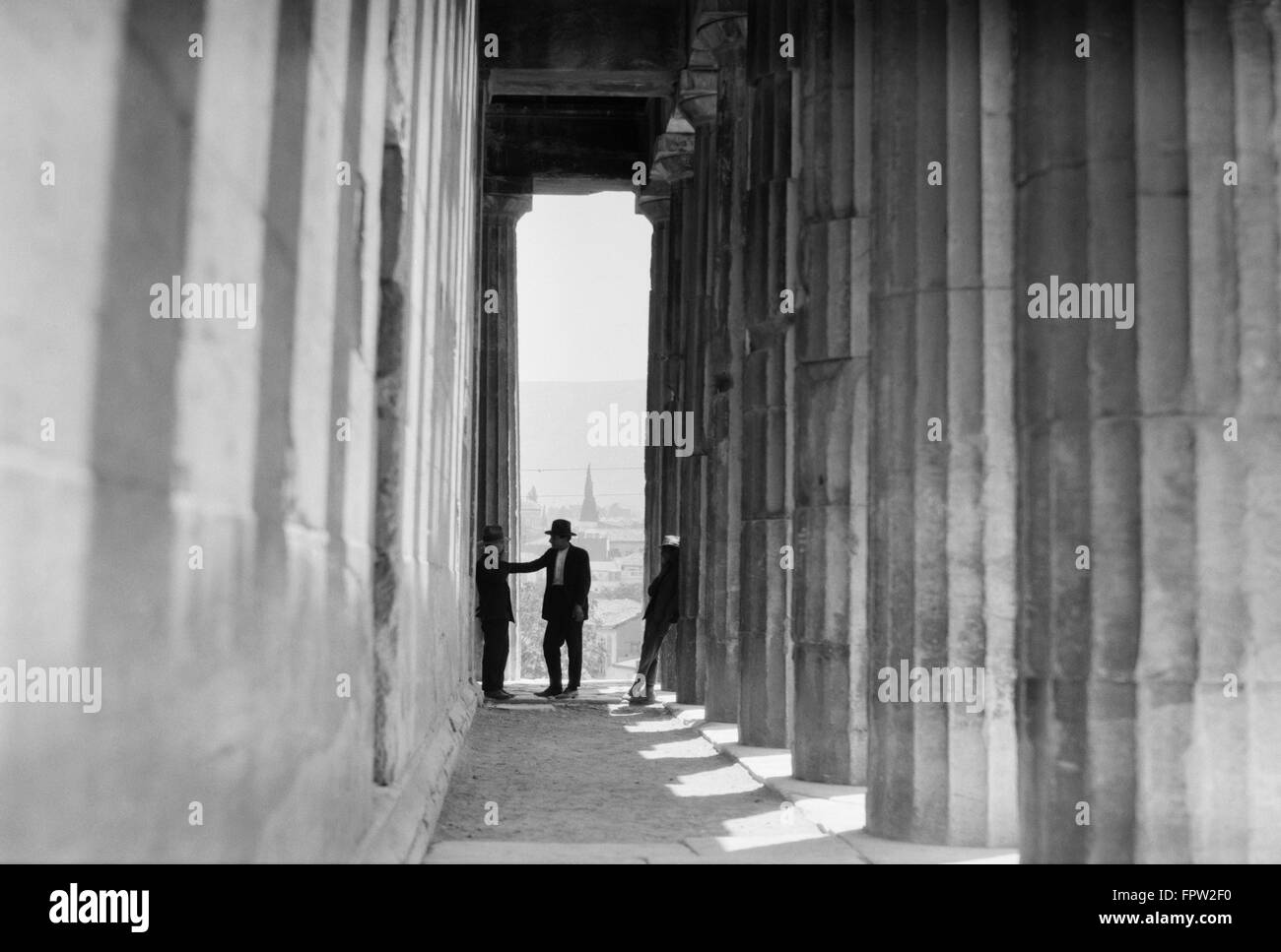 Années 1920 Années 1930 TROIS HOMMES DEBOUT DANS LA COLONNE passage bordé d'Athènes GRÈCE TEMPLE D'HÉPHAÏSTOS Banque D'Images