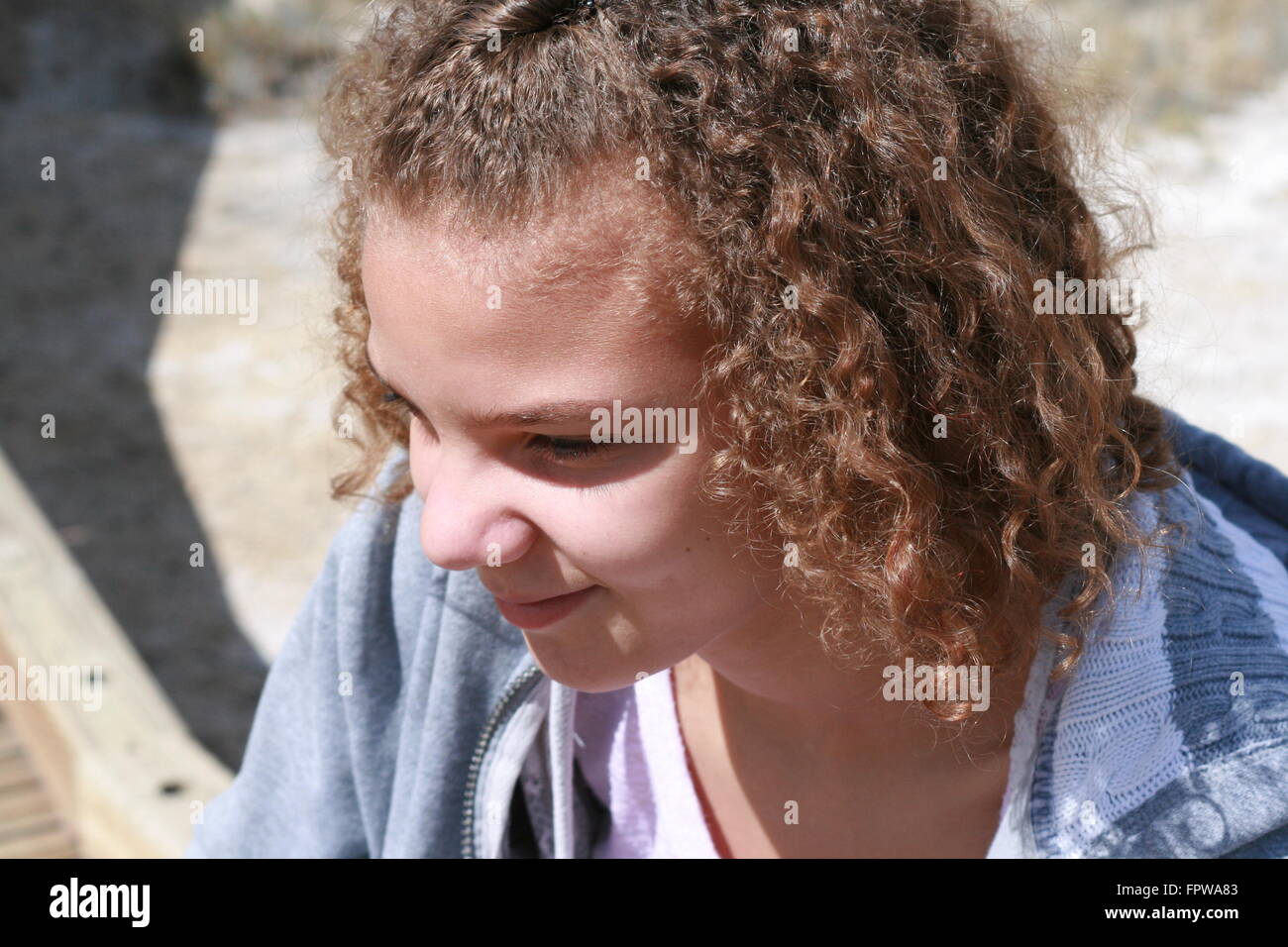 Belle Mixed Race girl sitting outdoors Banque D'Images