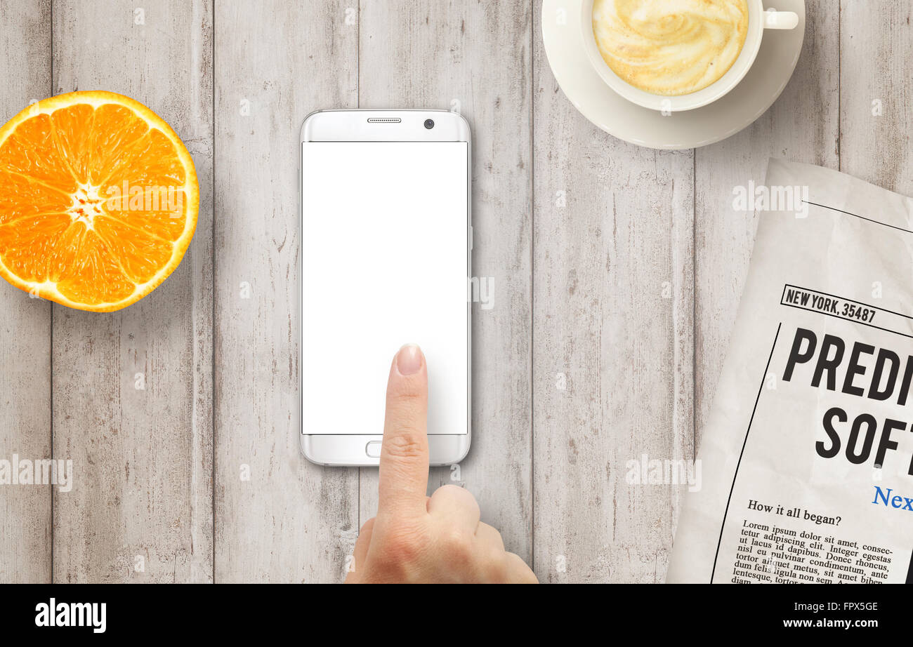 Téléphone intelligent avec affichage isolé pour une maquette. Part de toucher l'écran. Journaux, café et orange sur la table. Vue d'en haut. Banque D'Images